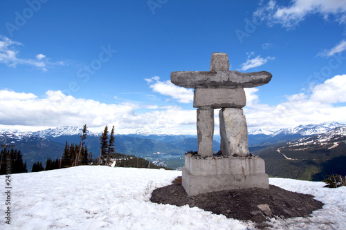 Whistler Peak inukshuk with snow and mountains photo