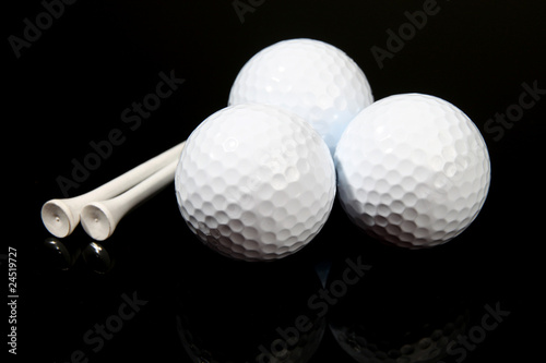 Golf balls and tees on black