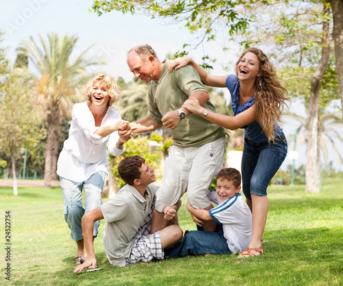 Family holding back grandfather and having fun