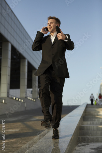 Young businessman calling on mobile phone, outdoor. photo