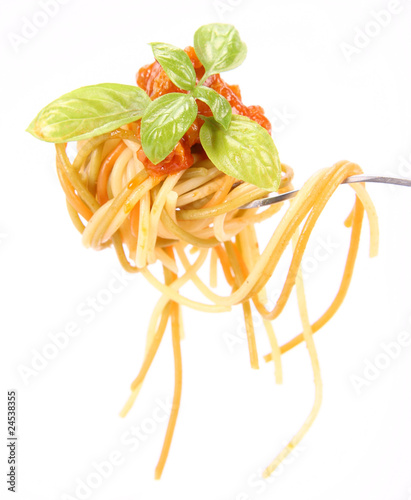 Spaghetti bolognese with basil leaves on a fork