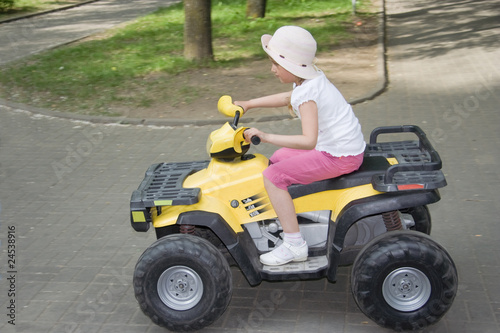 girl driving a toy-car