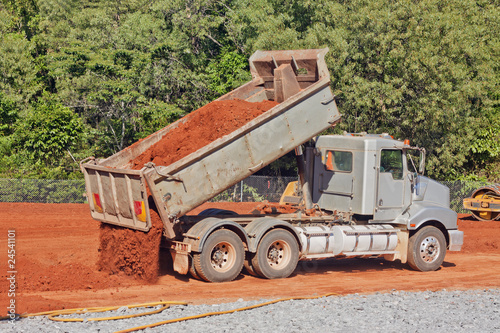 Tip truck dumping dirt on a construction site