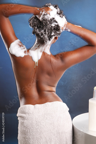 Cute African American washes her hair away from the camera