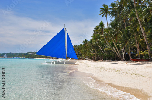 traditional paraw sailing boat on white beach on boracay island photo