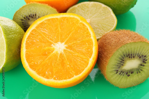 Orange and other fruits on green