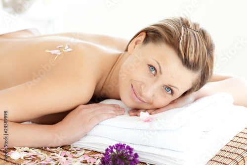 Cute caucasian woman having a massage smiling at the camera