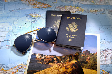 Two US American passports and sunglasses over map and brochure