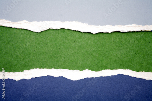 Blue ripped paper on green background. Copy space