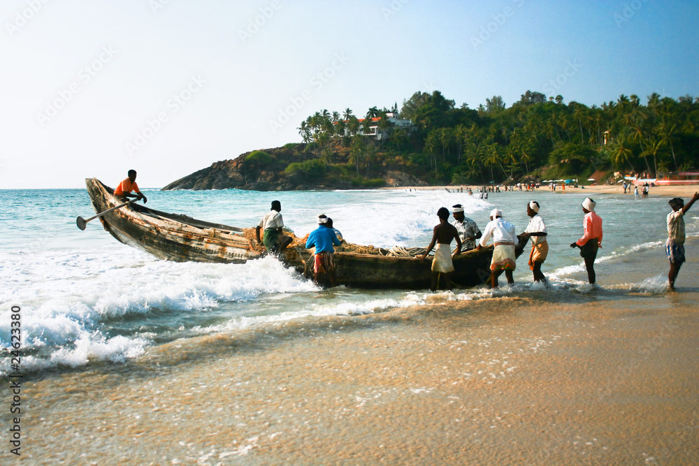 Fishermen bringing their traditional boat to the sea