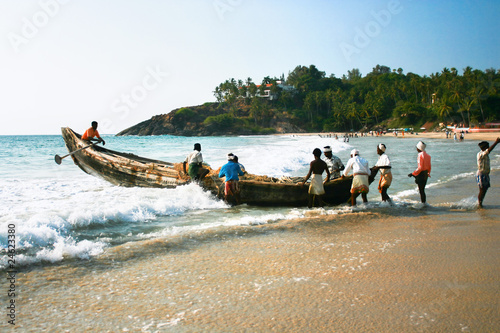 Obraz na płótnie Fishermen bringing their traditional boat to the sea w salonie