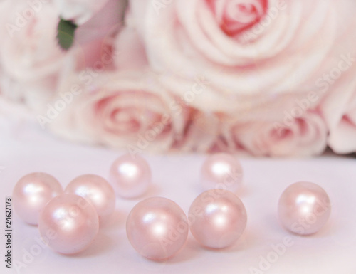 Close up of soft pink pearls and creamy pink roses behind