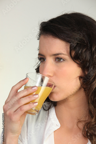 Portrait d'une femme buvant du jus d'orange