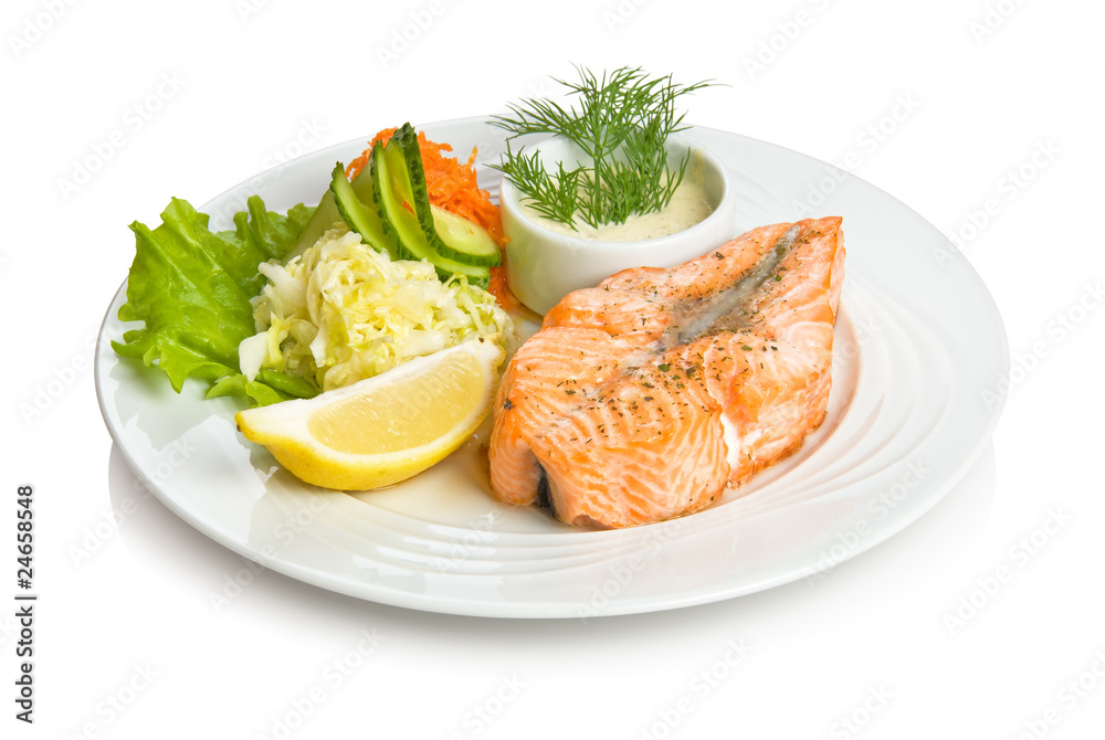 Fried trout steak with a vegetable side dish and sauce