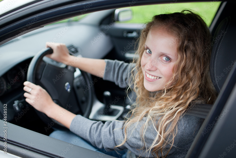 Pretty young woman driving her new car Pretty young woman driving her new car