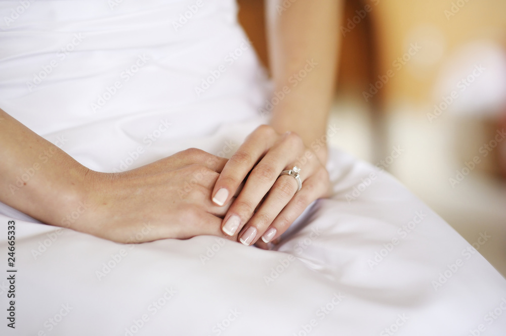 Beautiful woman's hands on a white dress