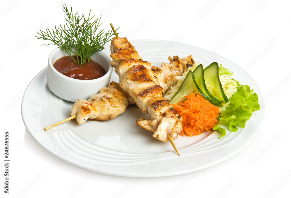 Chicken kebab with tomato sauce and vegetable side dish.