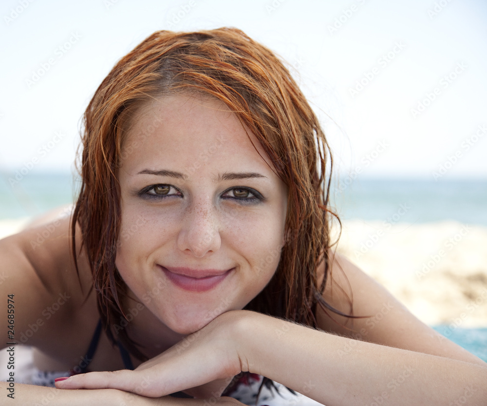 Sexy young red-haired girl on the beach.