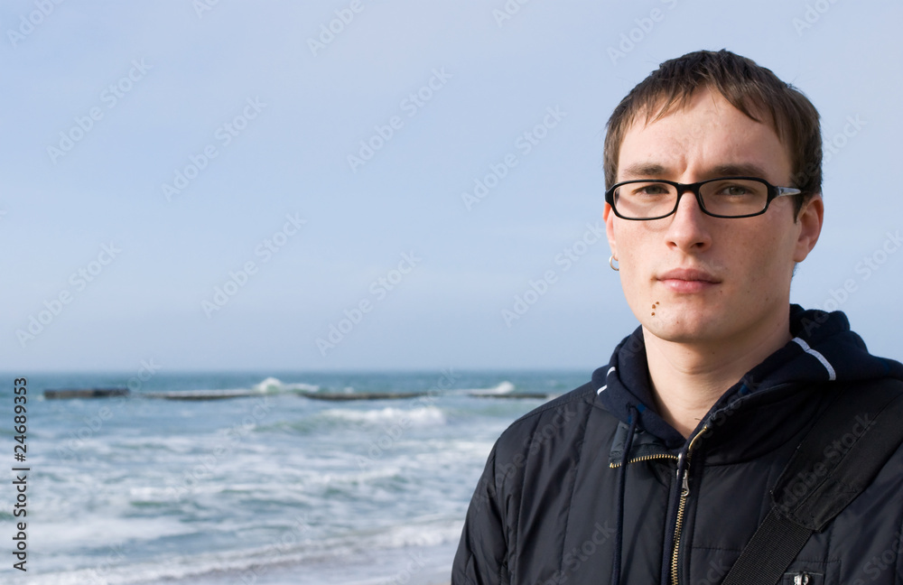 Young handsome man in glasses against a background Young handsome man in glasses against a background