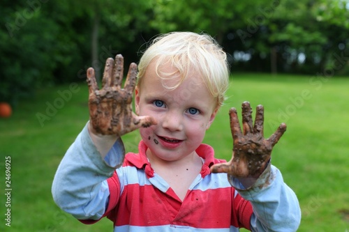 Ein Junge zeigt seine schmutzigen Hände