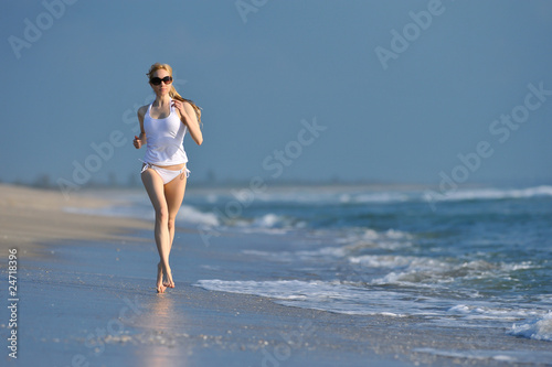 lovely blonde female jogging on beach