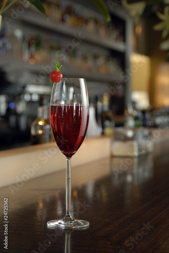 Kir Royal Cocktal with cherry tomato in a champagne glass.