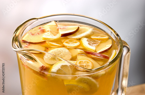 blanca sangria with pieces of apple, banana, oranges and lemon photo