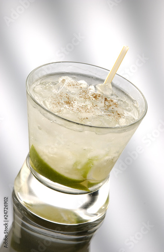 Glass of caipirinha with straw in front of a light background photo