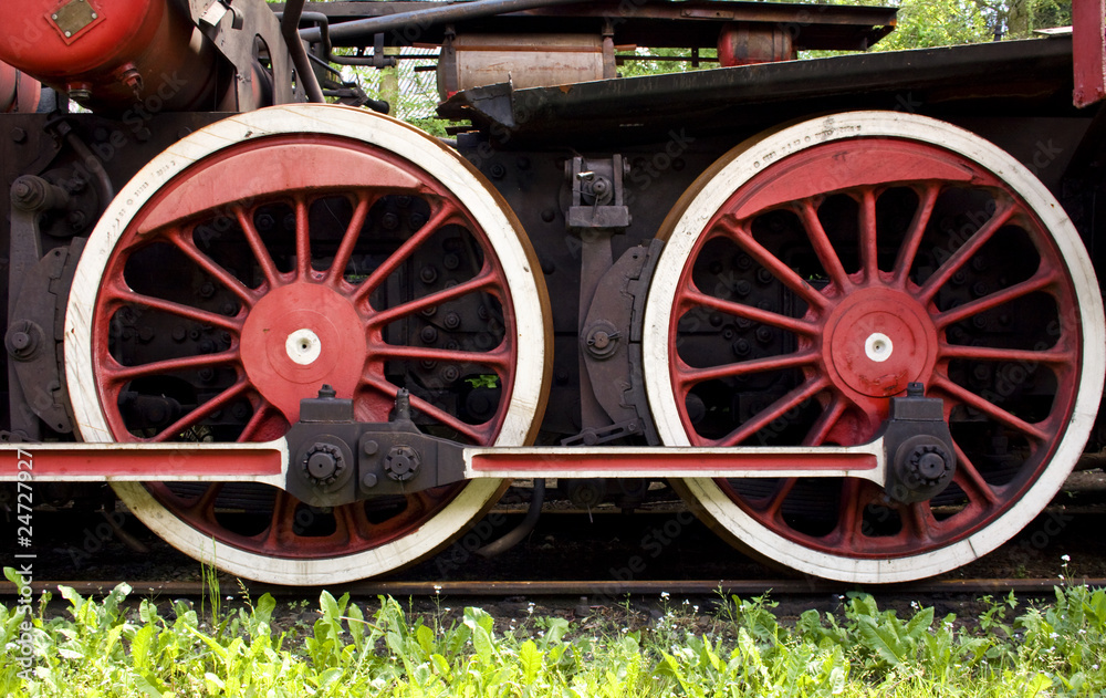 big red rusty wheels of old steam engine