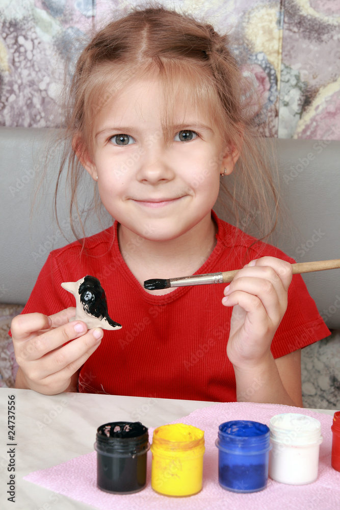 Smiling girl paints crafts