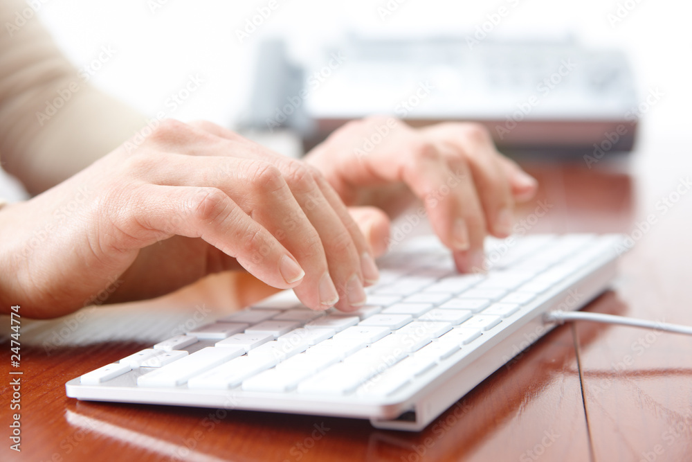 Business woman hands typing on the white keyboard.