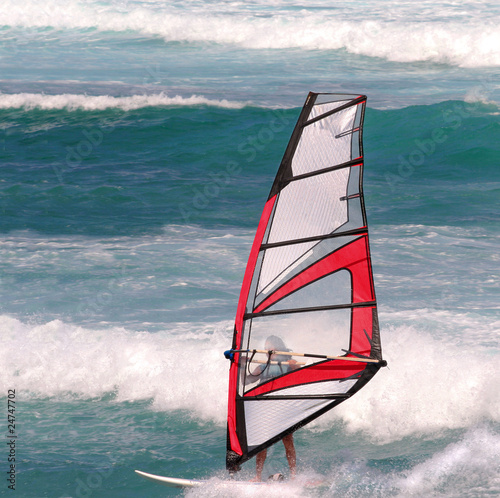 Female windsurfer in heavy waves