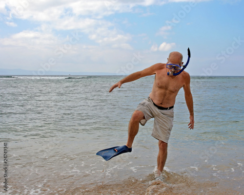 Retired senior man on beach with diving gear