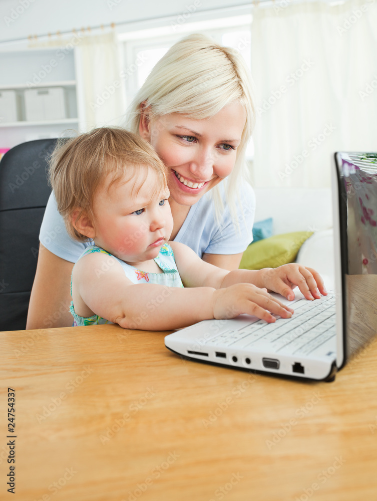 Blond mother and her daughter sitting in front of the laptop Blond mother and her daughter sitting in front of the laptop