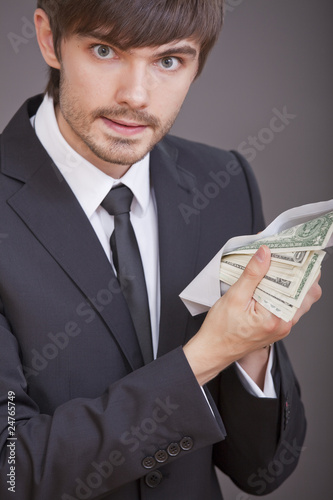 businessman holding dollars in envelope