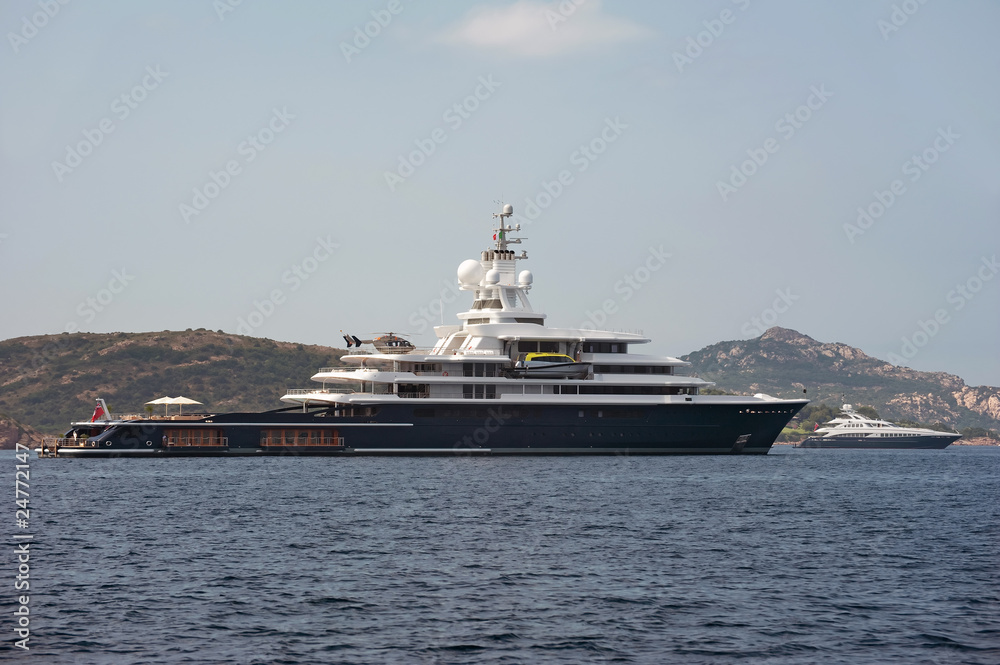 big yacht with helicopter on board anchored near Sardinia coast