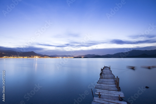 a romantic blue sunset with a jetty over a lake with an evening