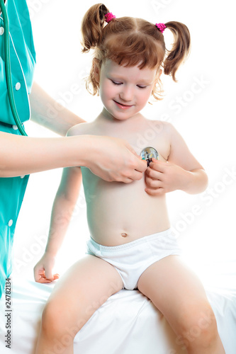 Doctor pediatrician examines little child using stethoscope