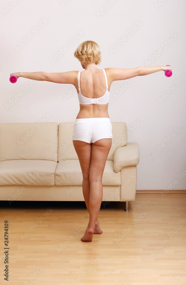 Fototapeta premium blond woman at home with dumbbell