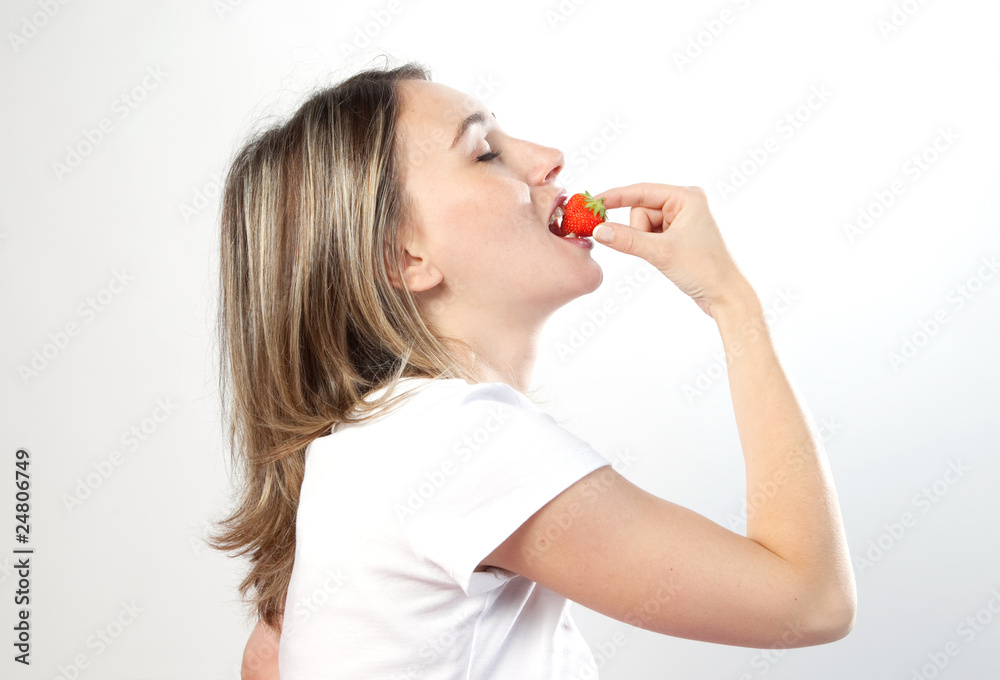 femme de profil mangeant une fraise femme de profil mangeant une fraise
