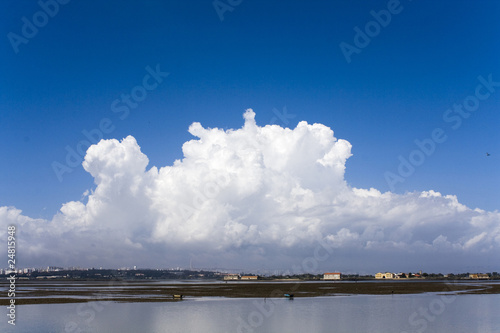 Big cloud in the blue sky with the city in wide view