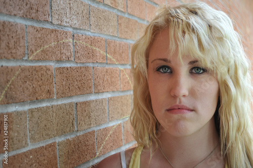 Girl standing next to brick wall