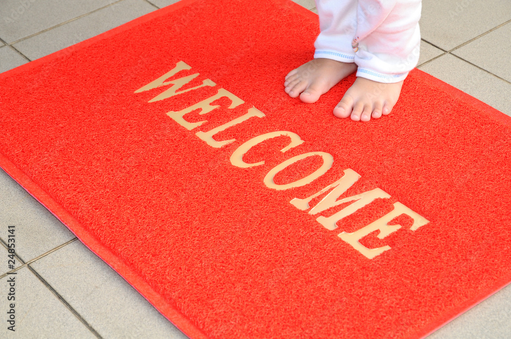 Child Standing On A Red Welcome Mat Stock Photo | Adobe Stock