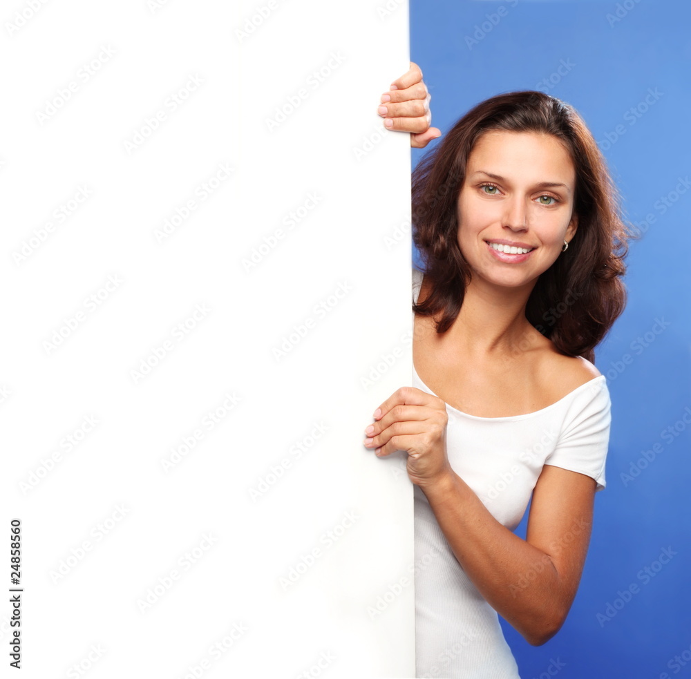 Beautiful brunette holding the edge of a white billboard Beautiful brunette holding the edge of a white billboard