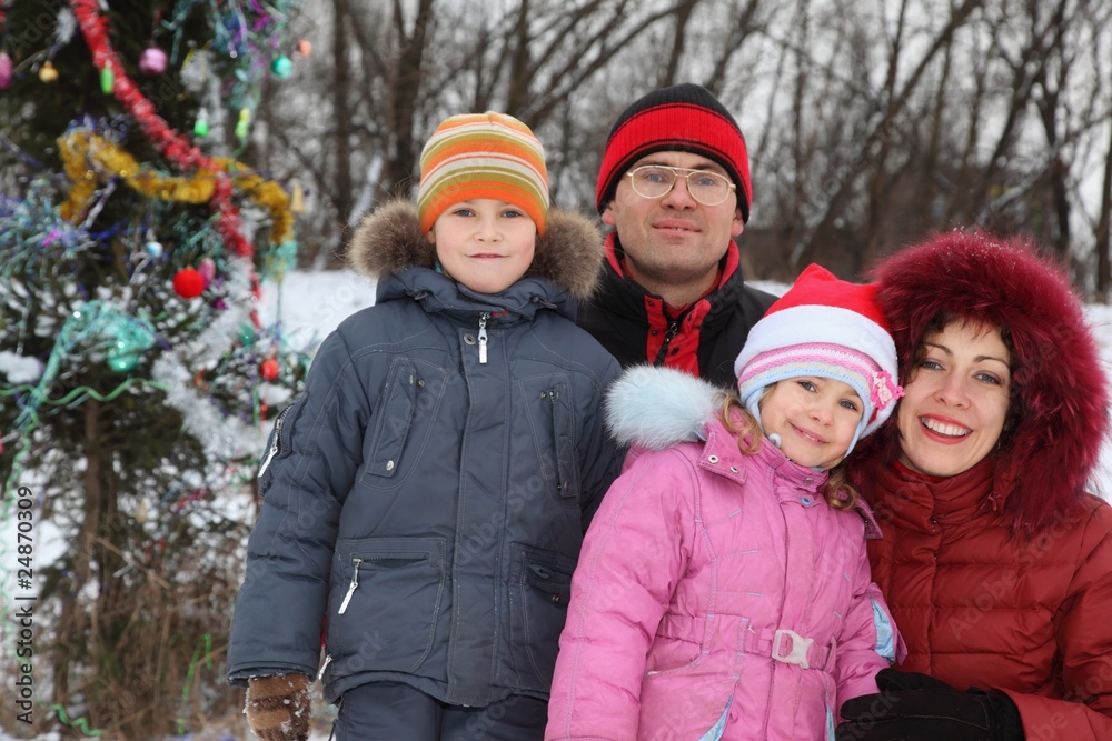 family with two children near christmass tree.