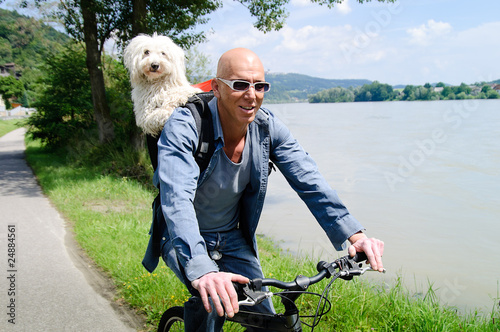 Radfahrer mit Hund im Rucksack photo