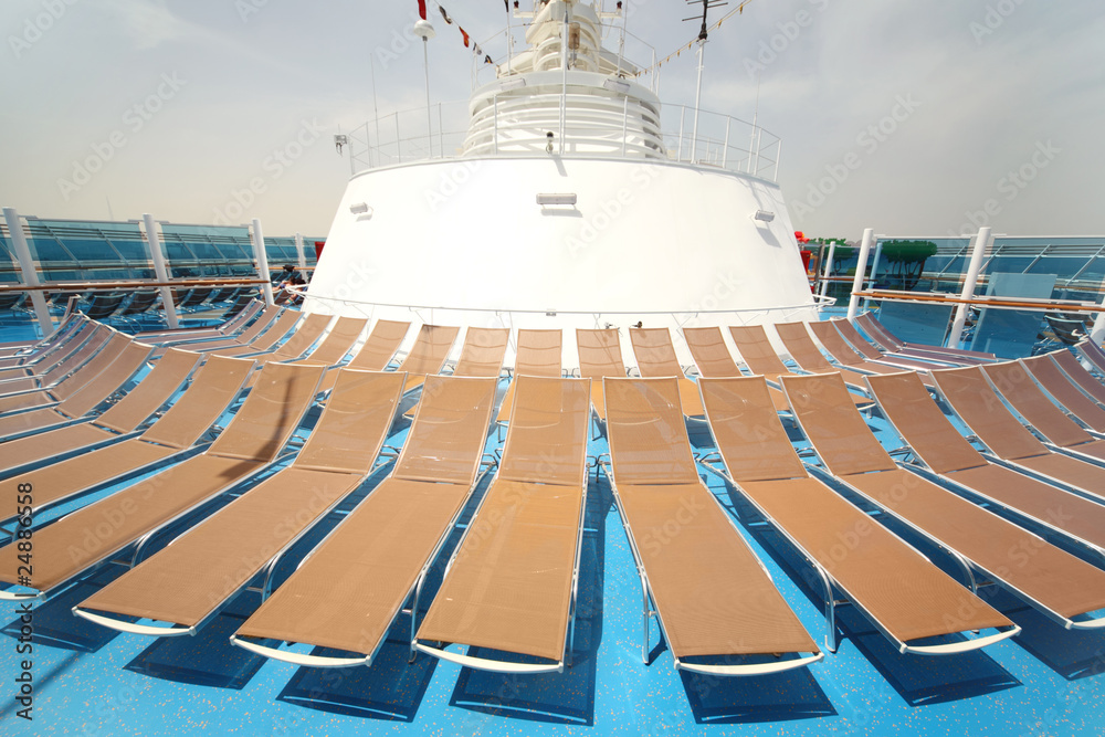 brown beach chairs on blue ship deck summer day
