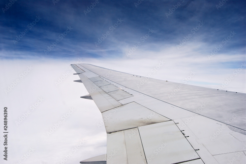 Blick auf Flugzeugflügel in der Luft über den Wolken