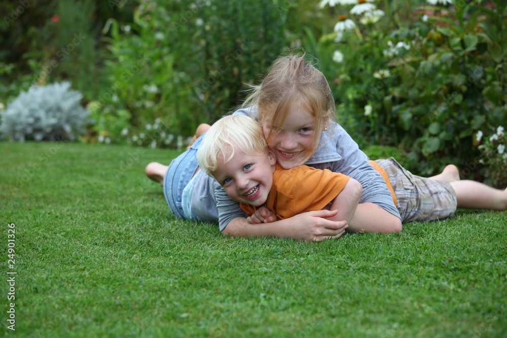 Kleiner Junge und Mädchen spielen im Garten Kleiner Junge und Mädchen spielen im Garten