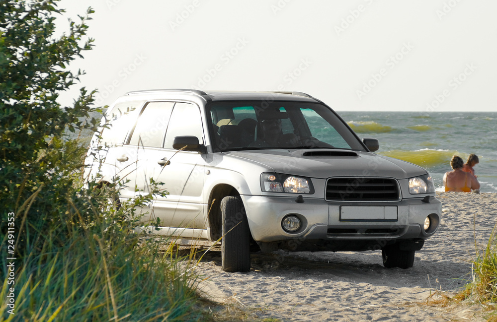 SUV stands on the beach on the background of the sea